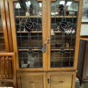 Edwardian light wood display cabinet (two leaded glass doors with stained glass inset, three open shelves and double cupboard under)